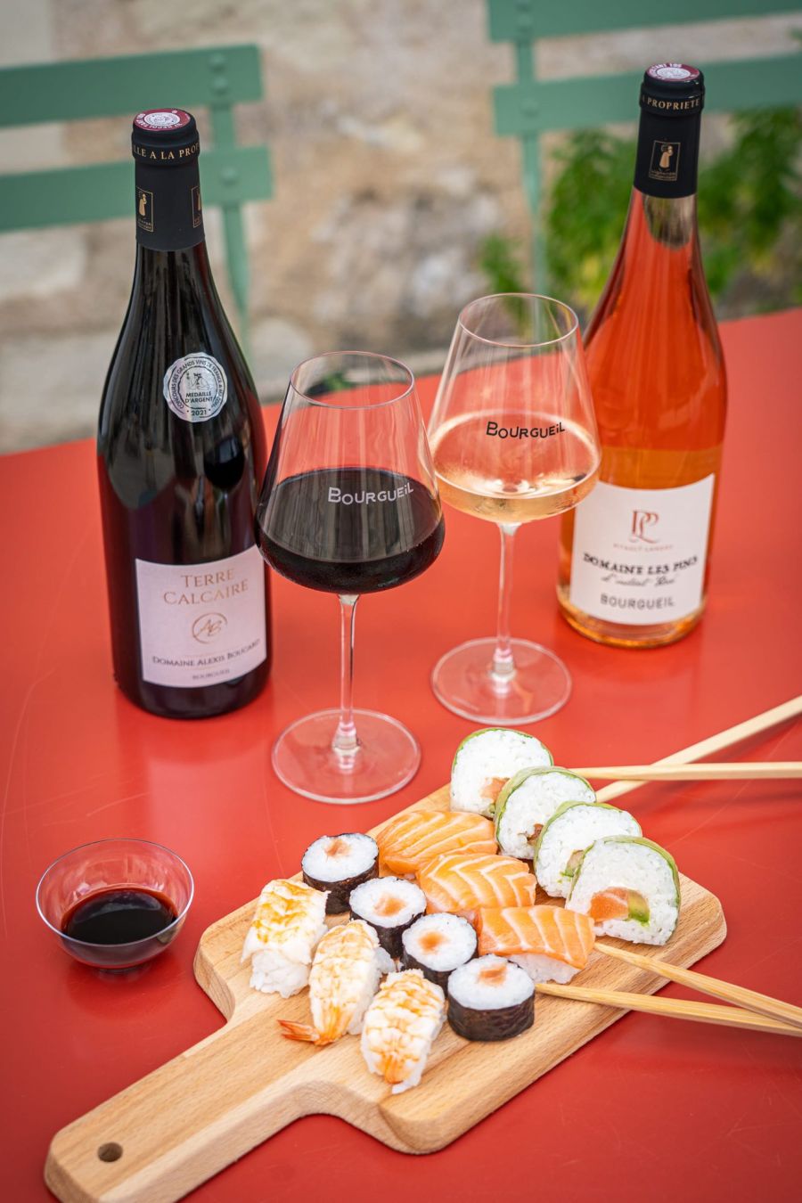Bouteilles de vin rouge et rosé avec un plateau de sushis, en mise en scène