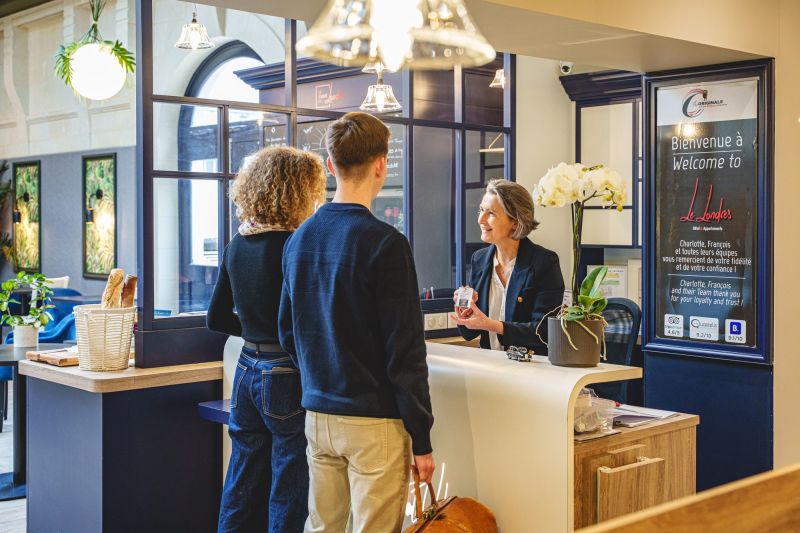 Accueil de clients à la réception de l’Hôtel Le Londres, à Saumur, lors d’un reportage photographique de Pixim